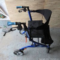 Side view showing blue frame and black seat, hand brakes and wheels visible.