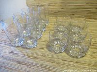 Group view of six tall and six short vintage Italian glasses on a patterned surface.