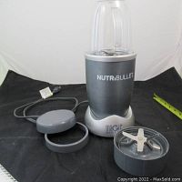 Nutribullet blender base with blade assembly, two blending cups and power cord.