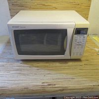 Front view of Sharp Carousel microwave oven showing door with window and control panel on right side.