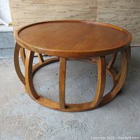 Front three-quarter view showing circular top and curved slat base