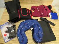 Photo showing a variety of black, maroon, blue knee and ankle braces, including Champion heat/ice wrap, neoprene braces with Velcro, and compression sleeves.