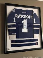 Framed blue and white Toronto Maple Leafs jersey with number 1 and RAYCROFT name on back inside black shadow box frame.