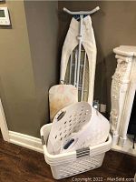 Two white plastic laundry baskets stacked together, showing handles and ventilation holes.