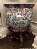 Front view of porcelain urn on wooden stand