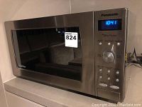 Front view of stainless steel microwave with brand label and sticker
