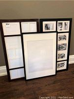 Three large photo frames grouped together, leaning against the wall