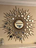 Full front view of round sunburst mirror mounted on wall