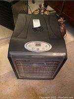 Front and top view of the black Chefman dehydrator showing digital control panel and front door with trays inside.