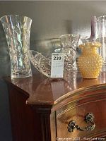 View of all three vases: two clear crystal glass vases and one small yellow milk glass vase with hobnail texture