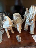 Front view showing three elephant statues including the large ceramic, one Lenox porcelain, and the small metal jeweled elephant.