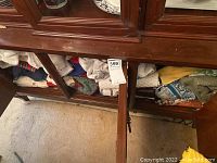 Linens and towels folded and stored inside wooden cabinet shelves.