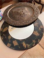Photo showing both the metal wall plate and the circular mosaic edge beveled mirror together on a table.