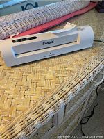 Front view of white Scotch laminator with control buttons and laminating slot.