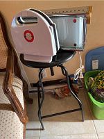 Photo of black metal stool with toaster and waffle maker placed on top showing overall size and look