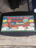 Top view of vintage horse racing board game "They're at the Post" box in shrink wrap showing colorful game artwork and details