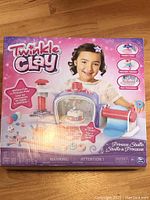 Front side of the Twinkle Clay Princess Studio box showing logo, images of kid playing with set, and key features of the kit including a clay drying oven, cutter, and clay extruder tool.