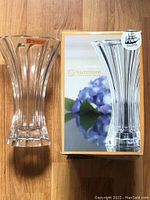 Full view of clear crystal vase with Nachtmann branding label beside its original box which features an image of the vase.