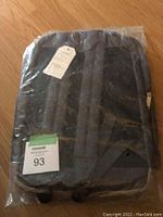 Back view of new laptop backpack showing padded shoulder straps and back panel for laptop protection, sealed in plastic.