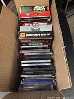 Box containing various PC software titles including visible Grand Theft Auto III and Def Jam Vendetta game cases