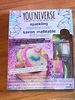 Photo of sealed You 'Niverse Sparkling Squishy Soap Craft Kit showing front of box with colorful graphics and components included
