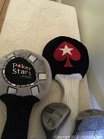 Two golf drivers leaning against a wall, showing club heads and protective covers with marked numbers.