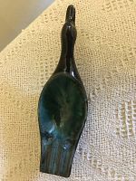 Top view of ceramic bird-shaped ashtray showing glossy dark green glaze, hollow body cavity and tail feathers holder.