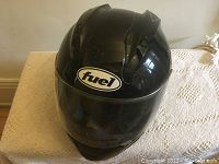 Front view of glossy black Fuel motorcycle helmet with clear face shield showing minor surface scratches.