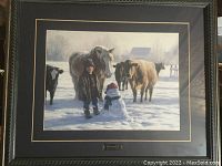 Framed print showing a winter scene with a young boy, horse, and cows in snowy farm setting
