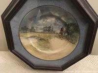 Front view of Royal Doulton decorative plate depicting a country scene, mounted in an octagonal wooden frame with blue mat.