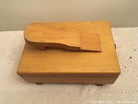 Top view of wooden shoe shine box showing footrest on lid and rectangular shape