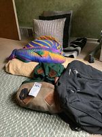 Photo depicting the lot with plush dolphin pillow, backpacks, throw pillows, and folded comforter/blanket.