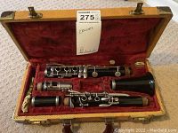 Bundy B clarinet disassembled into mouthpiece, barrel, upper joint, lower joint, and bell resting in a red velvet lined case.