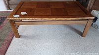 Full view of the rectangular wooden coffee table with panel style top and square wood grain pattern