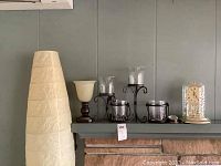 View of floor lamp, candle holders, and clocks on mantle