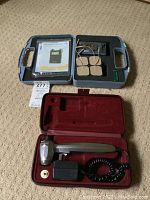 Full view of both closed carrying cases containing TENS/EMS unit with electrode pads and the electric massager with accessories.