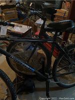 Overview of two bikes side by side in basement workspace showing frames, tires and general condition