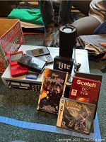 Overview of lot showing Toshiba DVD/VCR, two DS Lites, GBA SP, speaker, VHS tapes and game cases