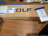 Long cardboard box with WOLF logo and shipping labels
