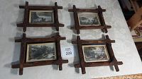 Four vintage wooden framed prints arranged together on a table with auction lot number visible
