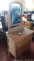 Side view of antique maple dresser with attached tilt mirror.