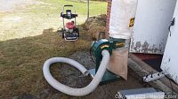 Wide view of Craftex dust collector with cloth bags and hose alongside a pressure washer