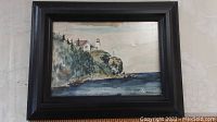 Framed watercolour painting of lighthouse on cliff with ocean view