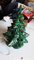 Front view of ceramic Christmas tree with green sculpted branches and multicolored bulbs.
