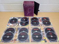 Top-down view of Alfred Hitchcock DVD box set with 10 individual DVDs laid out showing titles and box cover.