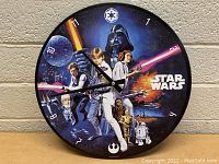 Front view of Star Wars themed round wall clock showing characters Luke Skywalker, Princess Leia, Darth Vader and others