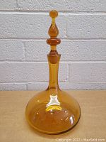 Full frontal view of the amber glass bottle with stopper