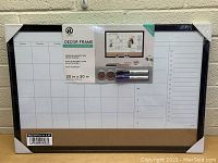 Photo showing two new dry erase wall hanging organizers with weekly calendar and corkboard strip under clear protective wrap.