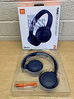 JBL Tune 510BT wireless headphones shown in packaging with box behind, displaying Pure Bass branding and Bluetooth logo.