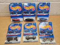 Front view of six new Hot Wheels cars in original blue 1989 First Editions packaging.